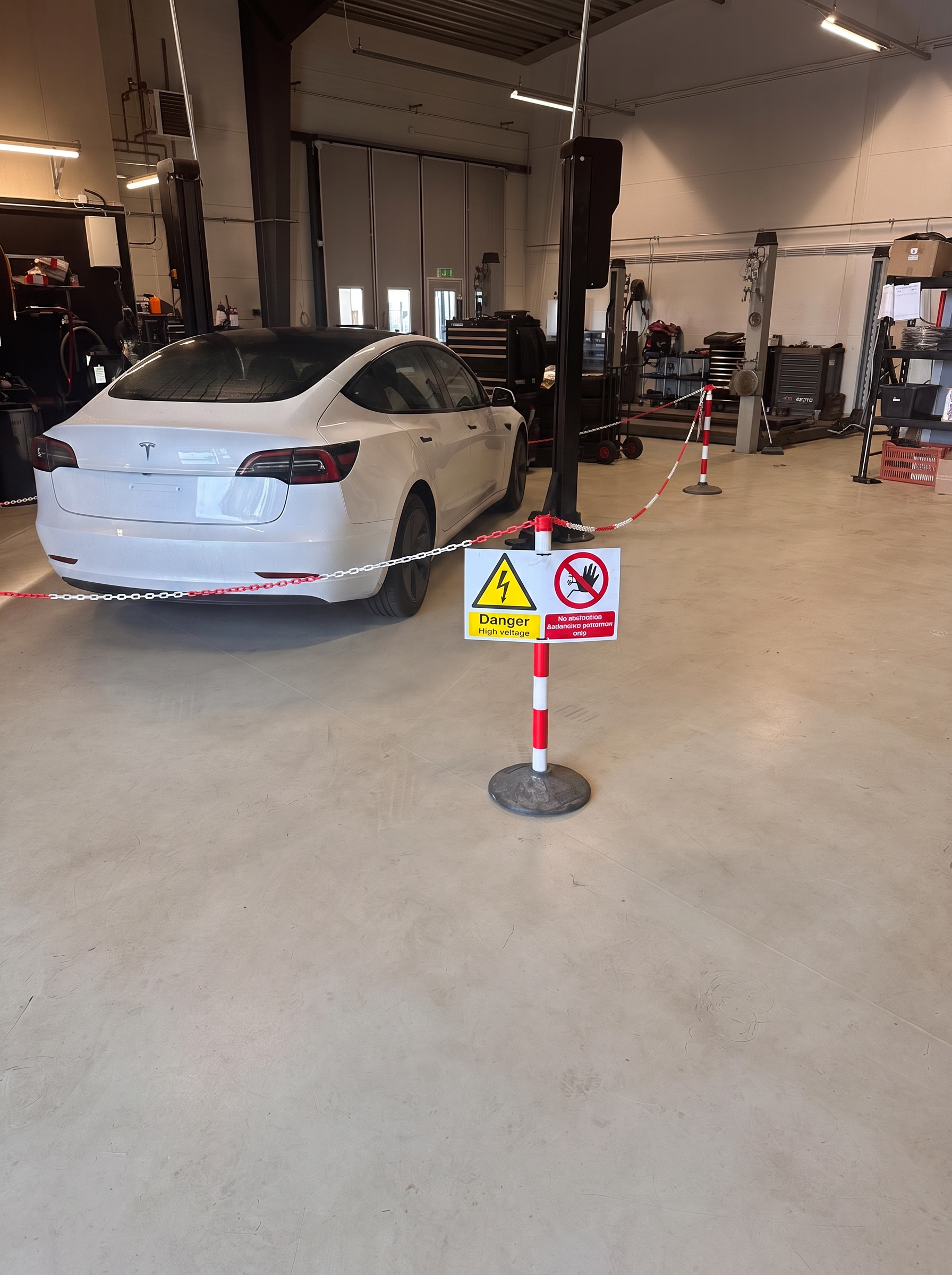 Vit Tesla Model 3 inne i verkstaden